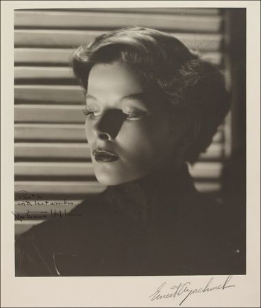 Lot #1054 Katharine Hepburn: Signing a superb early Bachrach photo - Image 1