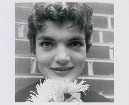 Lot #39 Jacqueline Kennedy Posing with a Flower in Her Backyard Photograph - Image 1